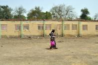 A mother of an abducted Chibok girl walks on April 14, 2015 past the school hostel where 219 schoolgirls were abducted by Boko Haram Islamists in the northeastern Nigerian city of Chibok in Borno State