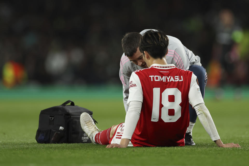 Arsenal's Takehiro Tomiyasu receives medical treatment during the Europa League round of 16, second leg, soccer match between Arsenal and Sporting CP at the Emirates stadium in London, Thursday, March 16, 2023. (AP Photo/Ian Walton)