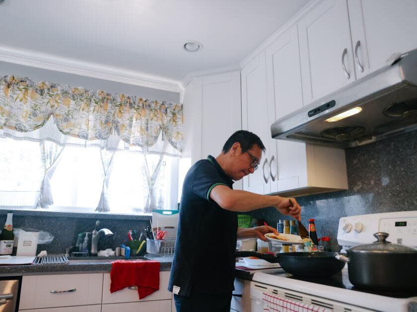 Johnny Wong prepares dinner at his home in San Mateo, Calif. 