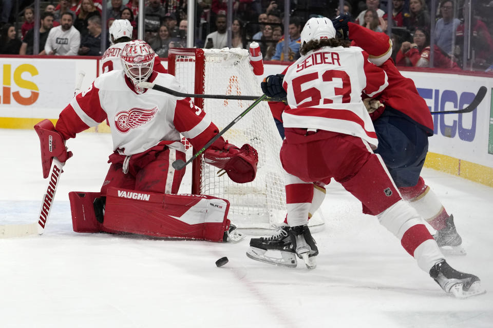 Detroit Red Wings goaltender Alex Nedeljkovic, left, watches the puck during the second period of the team's NHL hockey game against the Florida Panthers, Thursday, Dec. 8, 2022, in Sunrise, Fla. (AP Photo/Lynne Sladky)