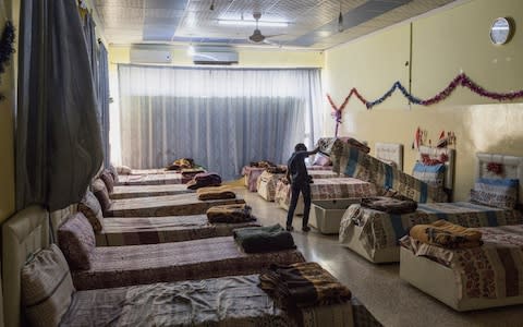 A child checks his personal belongings, which are stored beneath his bed, at an orphanage in Mosul, Iraq - Credit: Sam Tarling for The Telegraph