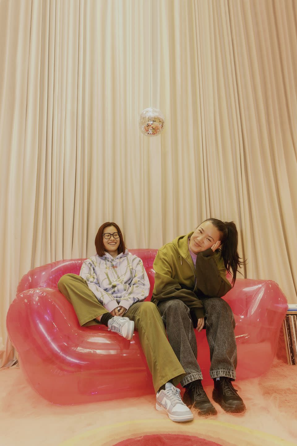 abi lierheimer and ophelia chen of bobblehaus sit on an inflatable couch