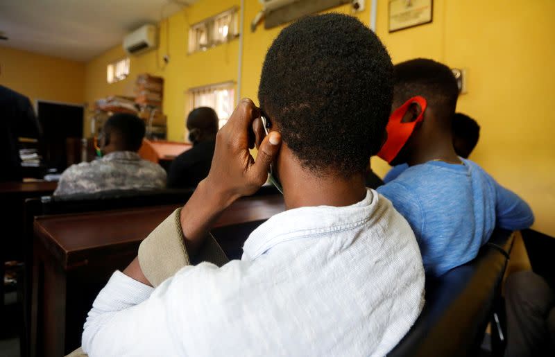 Some of the men charged with public displays of affection with members of the same sex sit inside a court in Lagos