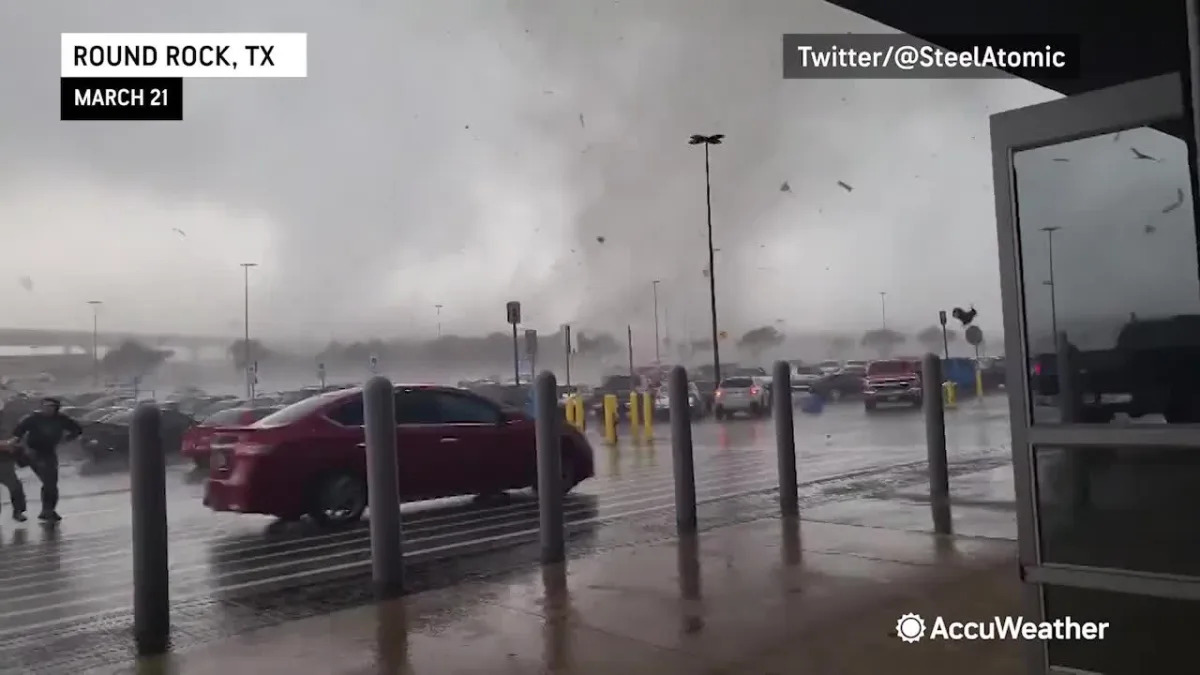 People sprint for a Walmart's doors as tornado rips through the parking lot