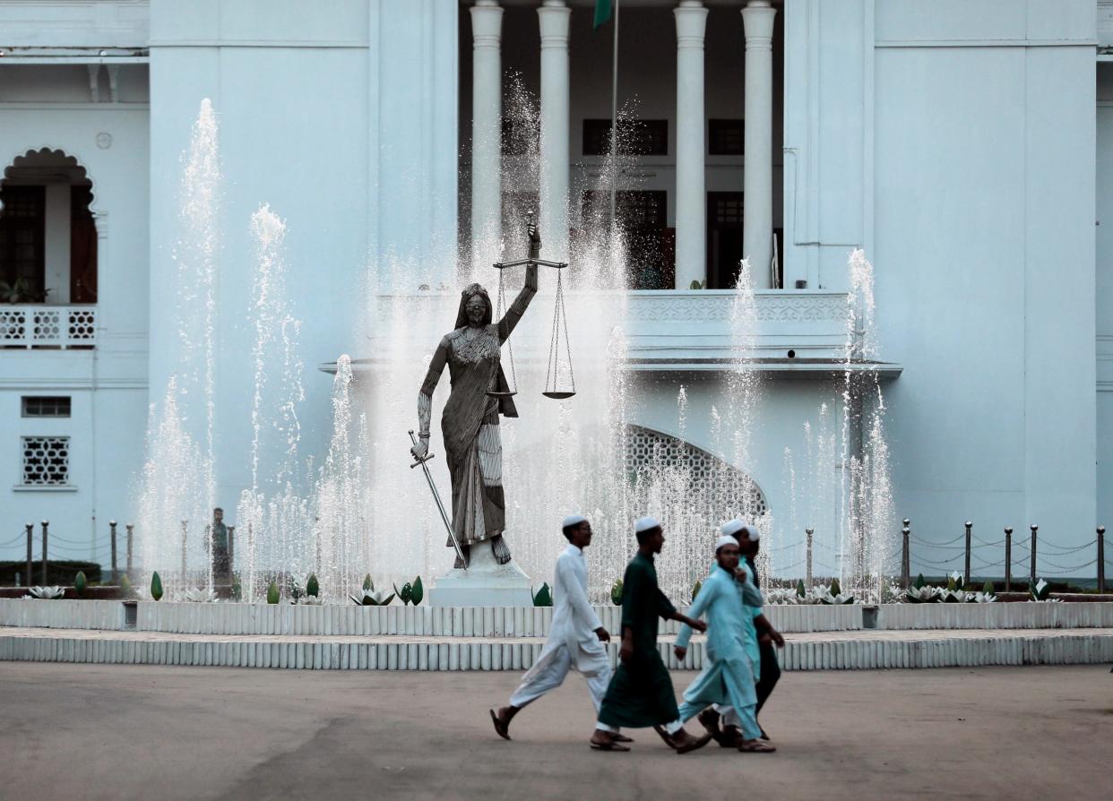 Bangladeshi Muslim boys walk past a Lady Justice statue at the Supreme Court complex in Dhaka, Bangladesh - Copyright 2017 The Associated Press. All rights reserved.