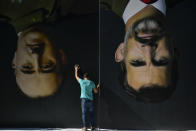 A man sets up upside down giant paintings of late Spanish dictator Francisco Franco, left, and Spanish King Felipe VI ahead of a protest by Basque pro-independence activists in support of Catalonia's independence movement following Spain's conviction of Catalan separatist leaders, in Bilbao, northern Spain, Tuesday, Oct. 15, 2019. Spain's Supreme Court on Monday sentenced 12 prominent former Catalan politicians and activists of illegally promoting the Catalonia region's independence. (AP Photo/Alvaro Barrientos)