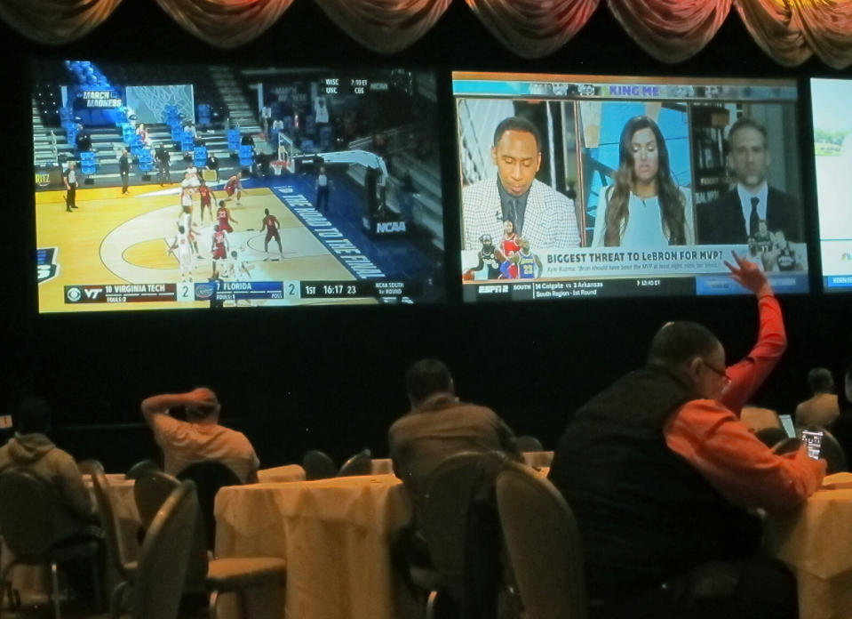 Customers watch a game in the NCAA basketball March Madness tournament on Friday March 19, 2021 at the Borgata casino in Atlantic City NJ. Last year, it was March sadness as the NCAA college basketball tournament got canceled days before it was supposed to start, due to the coronavirus. (AP Photo/Wayne Parry)