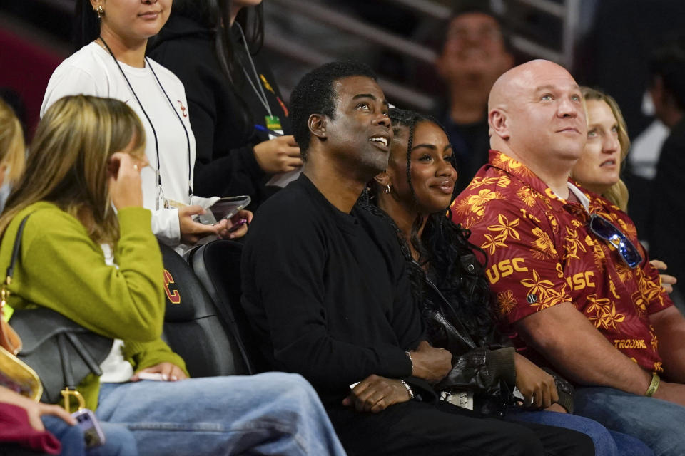 Comedian Chris Rock, center, watches during the first half of an NCAA college basketball game between Southern California and Cal State Bakersfield, Thursday, Nov. 9, 2023, in Los Angeles. (AP Photo/Ryan Sun)