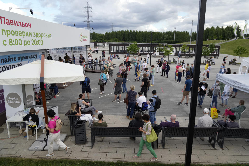 People wait in line to get a coronavirus vaccine at a vaccination center in a park in Moscow's outskirts, Russia, Thursday, July 1, 2021. Russian health authorities on Thursday launched booster coronavirus vaccination for those who had been immunized more than six months ago, as the country faces a surge in new infections and deaths. (AP Photo/Pavel Golovkin)