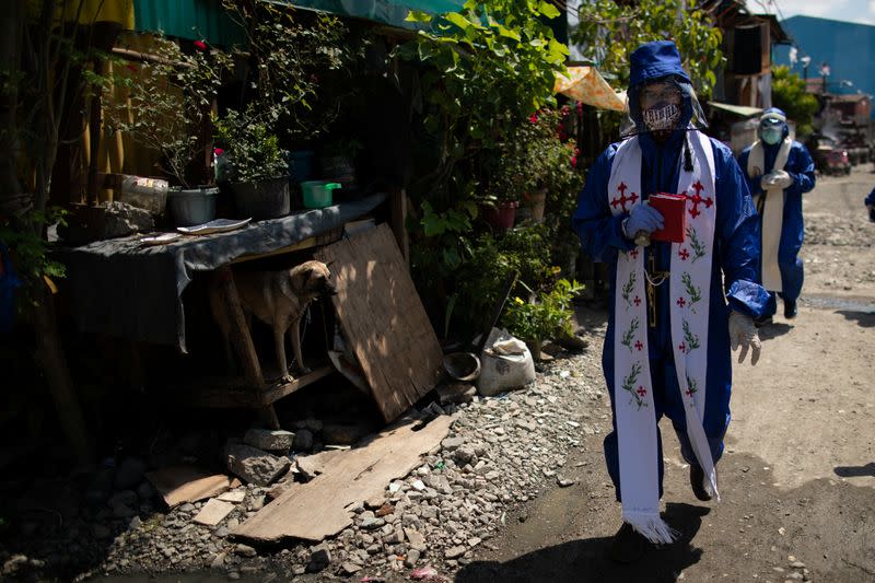 The Wider Image: Hazmat suits and holy water: two priests bring faith to Philippines lockdown