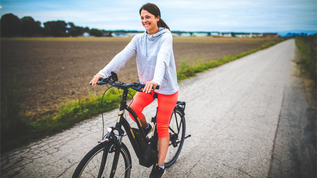  Woman riding on the electric bicycle. 