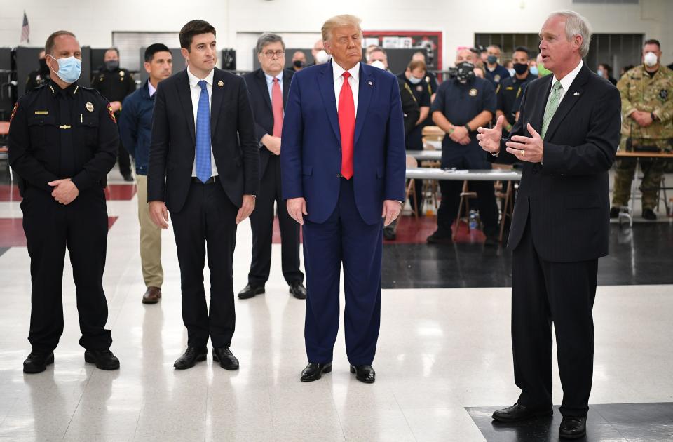 In this file photo, President Trump listens to Republican Sen. Ron Johnson during a tour of an emergency operations center at Mary D. Bradford High School in in Kenosha, Wisconsin on Sept. 1, 2020. Johnson easily won the Republican nomination in Wisconsin on Tuesday and will face a challenge from Lt. Gov. Mandela Barnes in the fall.