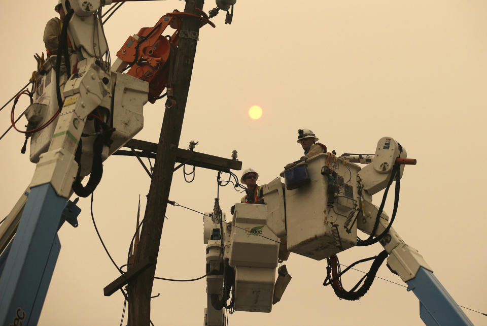 FILE - In this Nov. 9, 2018, file photo, Pacific Gas & Electric crews work to restore power lines in Paradise, Calif. Two years to the day after some of the deadliest wildfires tore through Northern California wine country, two of the state's largest utilities were poised Tuesday, Oct. 8, 2019, to shut off power to more than 700,000 customers in 37 counties, in what would be the largest preventive shut-off to date as utilities try to head off wildfires caused by faulty power lines. (AP Photo/Rich Pedroncelli, File)