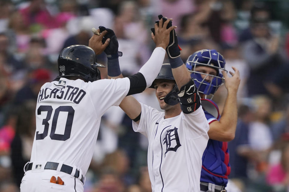 Detroit Tigers' Zack Short, center, is greeted at home by teammate Harold Castro after they both scored on Short's two-run home run during the second inning of a baseball game against the Texas Rangers, Wednesday, July 21, 2021, in Detroit. (AP Photo/Carlos Osorio)