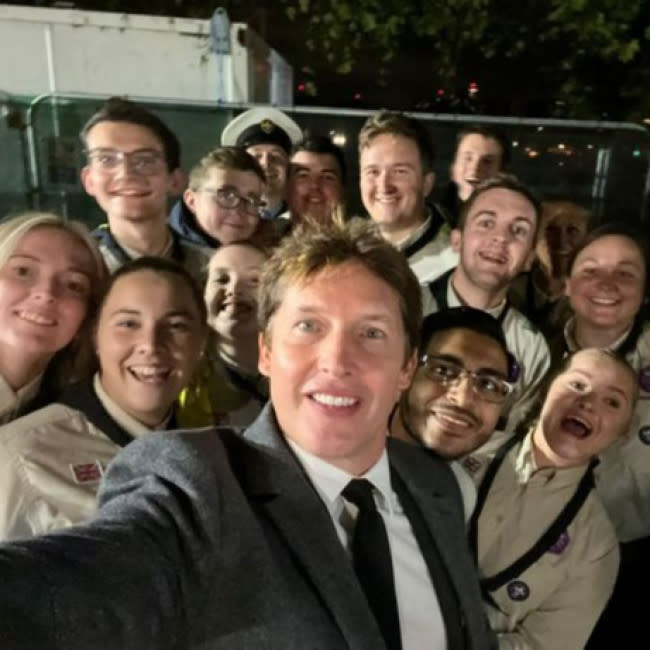 James Blunt con los voluntarios que ayudaban al público en la cola para ver el féretro de Isabel II credit:Bang Showbiz