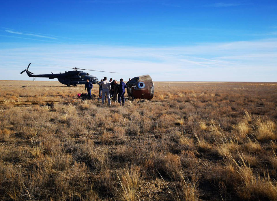 In this photo provided by Russian Defense Ministry Press Service, the rescue team gather next to the Soyuz MS-10 space capsule after it made an emergency landing in a field about 20 km (12,43 miles) Dzhezkazgan, about 450 kilometers (280 miles) northeast of Baikonur, Kazakhstan, Thursday, Oct. 11, 2018. NASA astronaut Nick Hague and Roscosmos' Alexei Ovchinin lifted off as scheduled at 2:40 p.m. (0840 GMT; 4:40 a.m. EDT) Thursday from the Russian-leased Baikonur cosmodrome in Kazakhstan, but their Soyuz booster rocket failed about two minutes after the launch. (Russian Defense Ministry Press Service photo via AP)