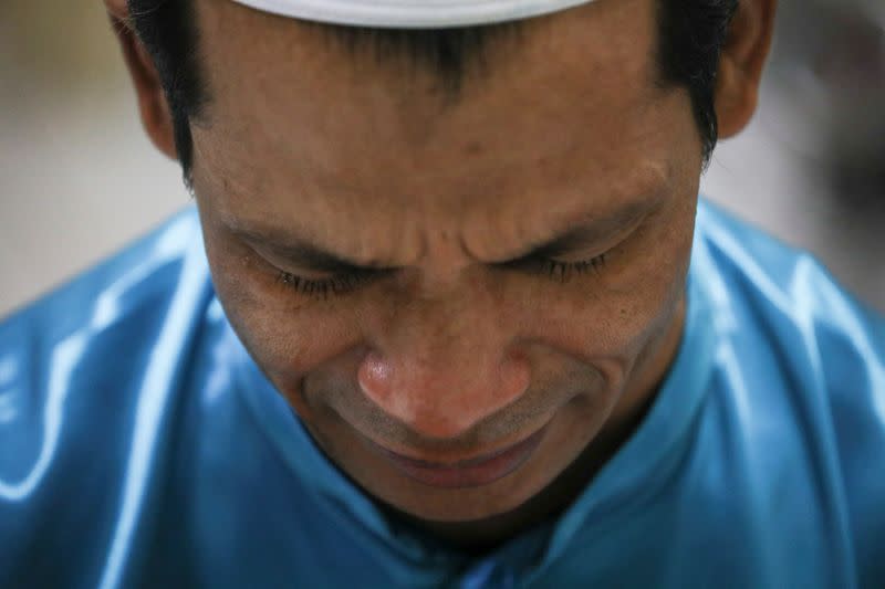 Rohingya refugee and activist Zafar Ahmad Abdul Ghani cries during a prayer at his home in Kuala Lumpur