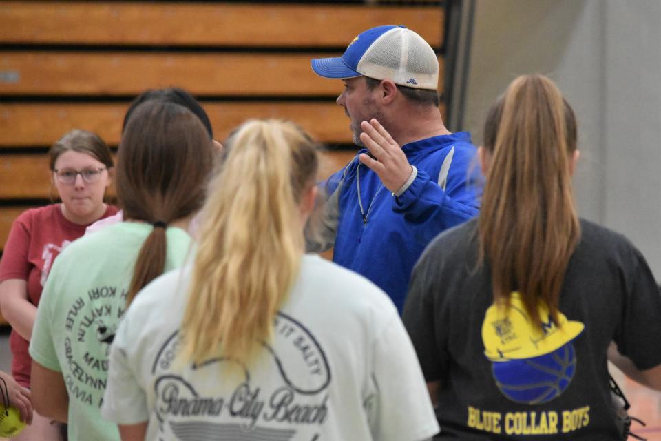 Mitchell softball coach Stevie Canada speaks with his team during its first official practice of the 2022 season.