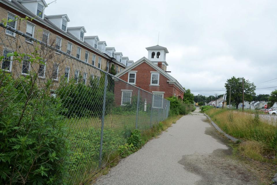 Work will be done to the sidewalk and grassy area in front of the former C & M Mill in Wauregan for the anticipated 1.6-mile Quinebaug River Trail in the Wauregan and Central Village sections of Plainfield.