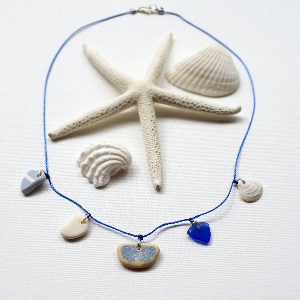 This undated publicity photo provided by Karen Vesk shows a necklace that incorporates blue beach glass, a small shell and several shards of beach pottery. Vesk, of Erie, Penn., hunts for beach glass and pottery shards at the Lake Erie shoreline. She visits Southern states' beaches for small shells and shell fragments, which she says have “an almost sculptural, abstract look to them." (AP Photo/Karen Vesk)