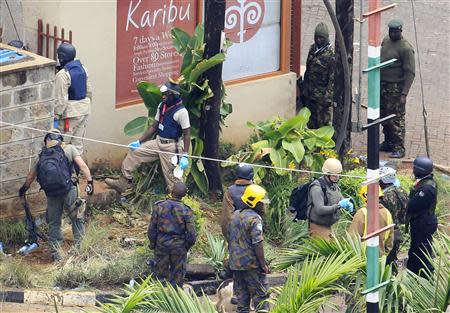 Foreign forensic experts, flanked by Kenyan military personnel, check the perimeter walls around Westgate shopping mall in Nairobi September 25, 2013. Bomb disposal experts and investigators searched through the wreckage of the Kenyan shopping mall on Wednesday after a four-day attack by Islamist militants that killed at least 72 people. REUTERS/Noor Khamis