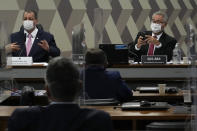 Senators Omar Aziz, left, and Renan Calheiros, attend a session by their commission investigating the government's management of the COVID-19 pandemic at the Federal Senate in Brasilia, Brazil, Tuesday, Oct. 26, 2021. (AP Photo/Eraldo Peres)