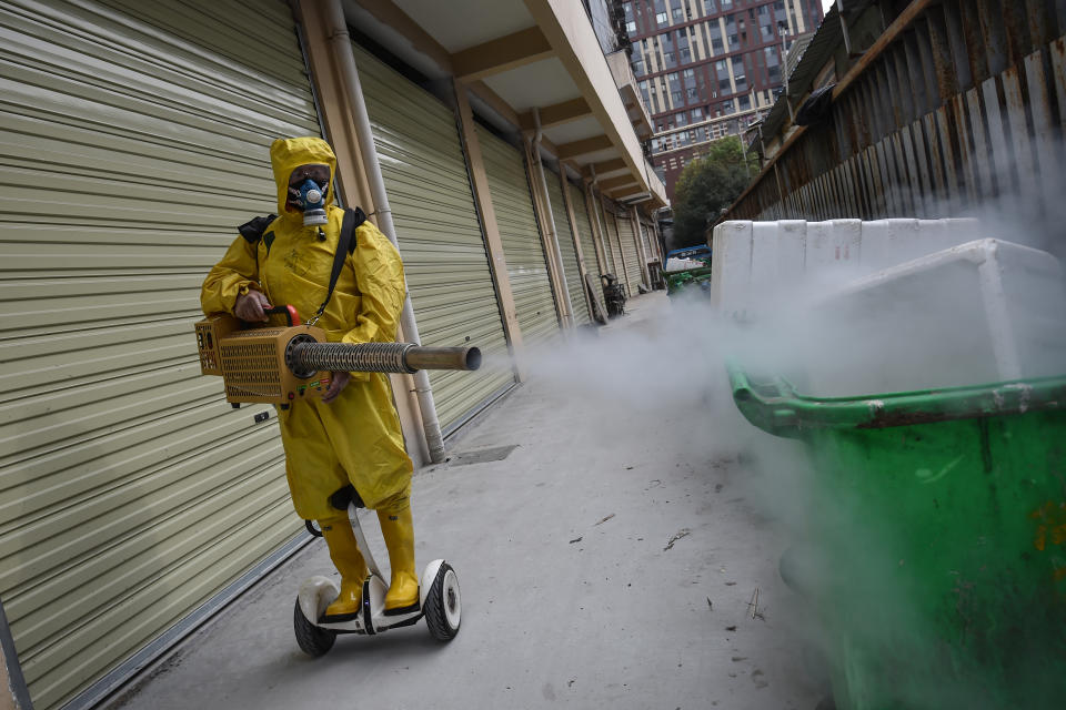 Un operario rocÃ­a con producto desinfectante una zona residencial de Wuhan, el 11 de marzo de 2020 en la ciudad china (AFP | .)