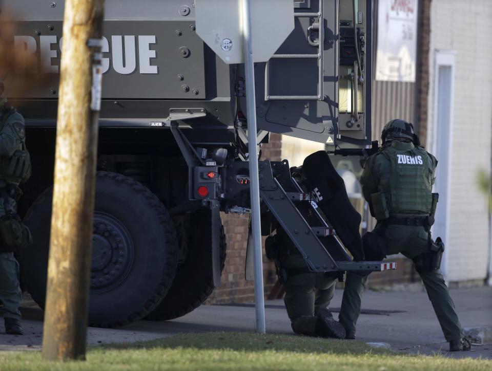 Police officers use an armored truck for cover during the Dec. 5, 2015, standoff and shooting at Eagle Nation Cycles in Neenah.