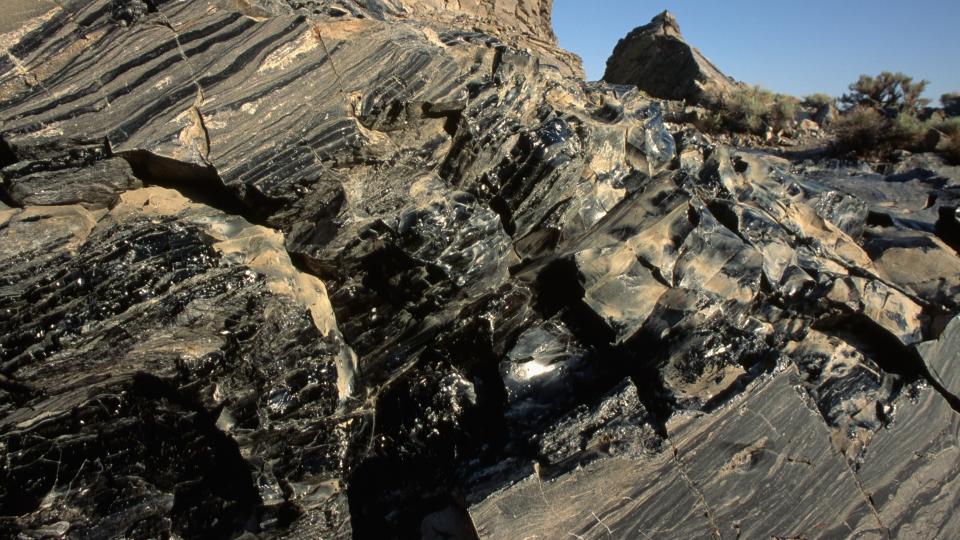 An outcrop of volcanic glass cemented to the ground.