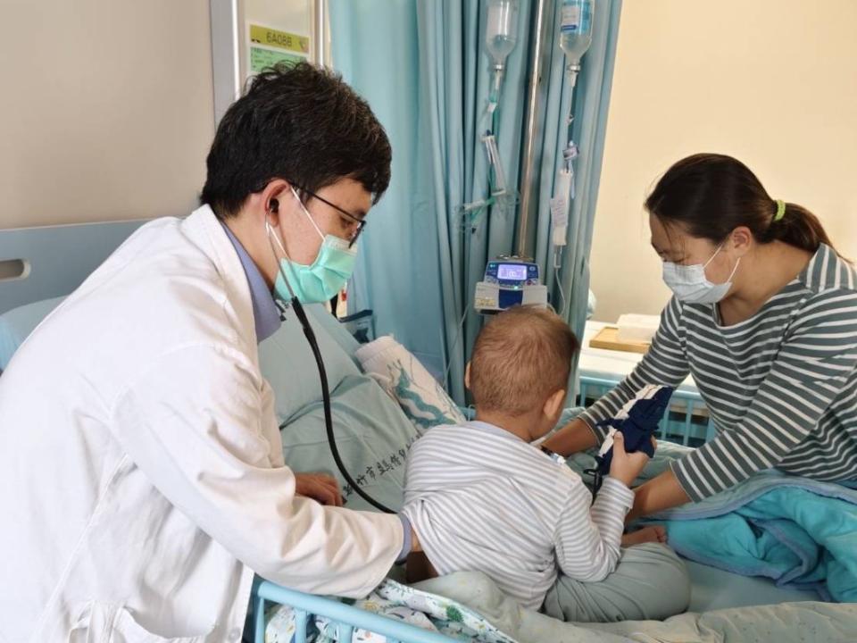 4歲王小弟罹患急性淋巴性白血病，醫師觸診病童頸部進行理學檢查。（新竹馬偕兒童醫院提供）