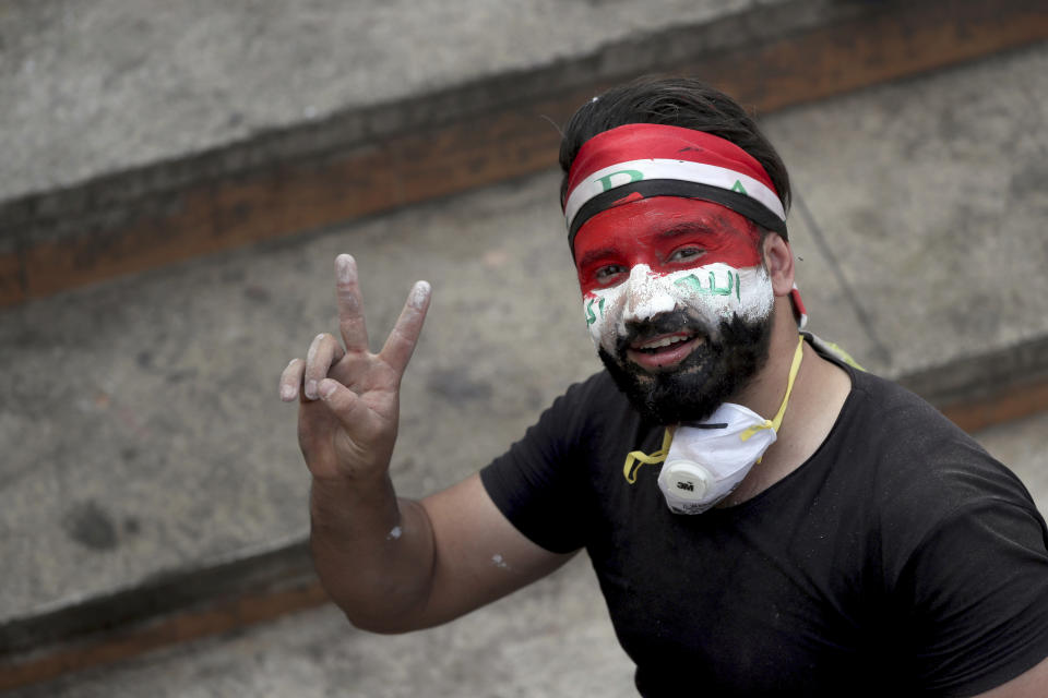 A protester with his face painted with the colors of the Iraqi flag flashes the victory sign during ongoing anti-government protests at Tahrir square in Baghdad, Iraq, Sunday, Nov. 3, 2019. (AP Photo/Hadi Mizban)