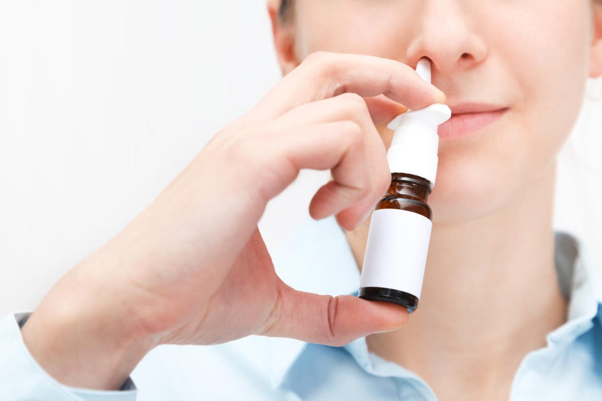 Woman using a nasal spray. Close-up shot.