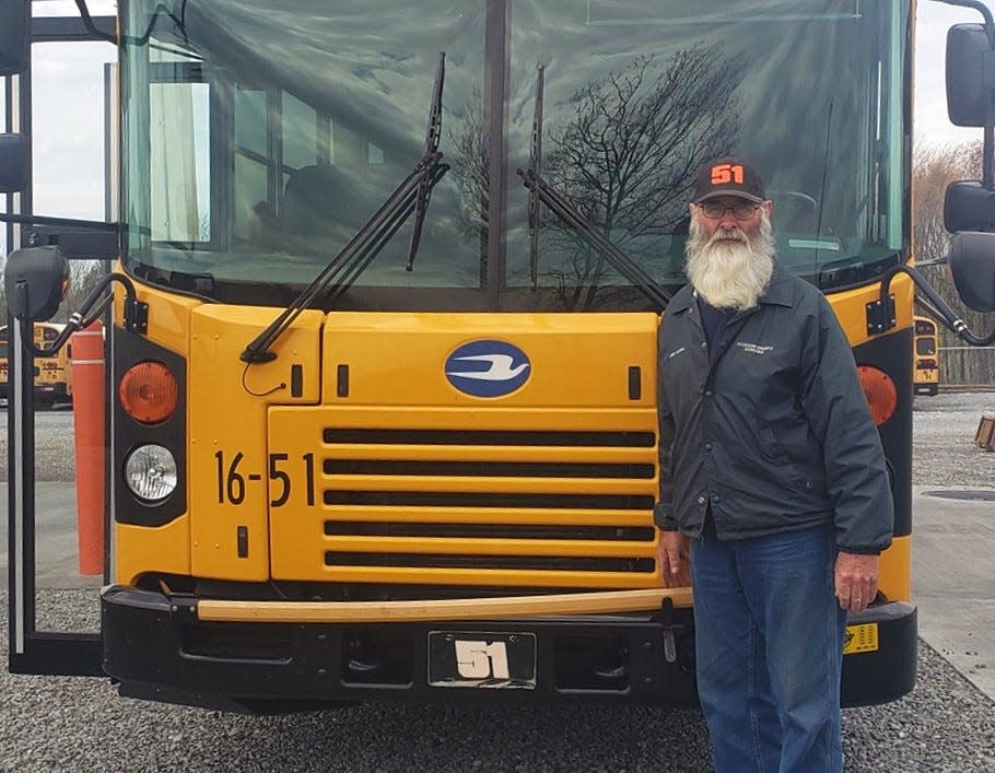 Randy Tidwell in front of bus No. 51. Tidwell has been bus driving for 50 years as of 2023.