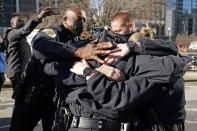 El jefe de la policía de Nashville, John Drake, izquierda, abraza a un grupo de agentes que a su vez se abrazan tras hablar en una conferencia de prensa el domingo 27 de diciembre de 2020, en Nashville, Tennessee. (AP Foto/Mark Humphrey)