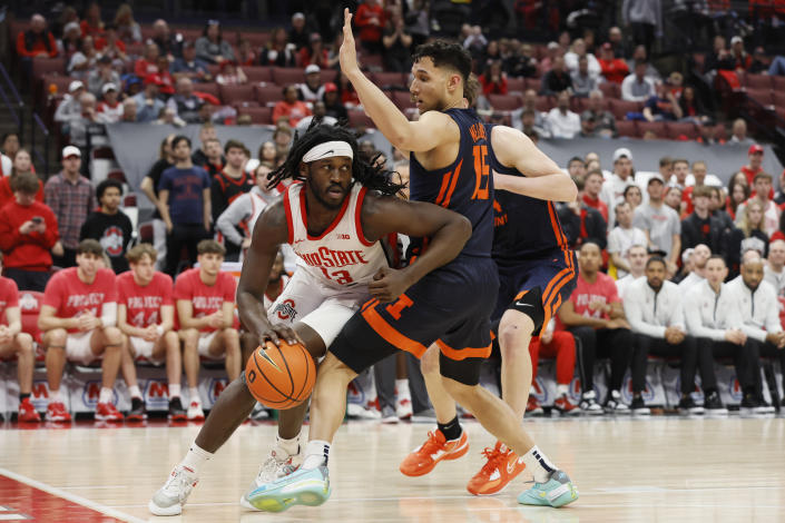 Ohio State's Isaac Likekele, left, drives the baseline around Illinois' R.J. Melendez during the second half of an NCAA college basketball game Sunday, Feb. 26, 2023, in Columbus, Ohio. (AP Photo/Jay LaPrete)