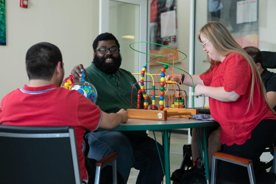 Direct support professional Walter McDowell, center, leads Pine Castle participants in a sensory-based curriculum activity. The Jacksonville nonprofit serves intellectually and developmentally disabled adults.