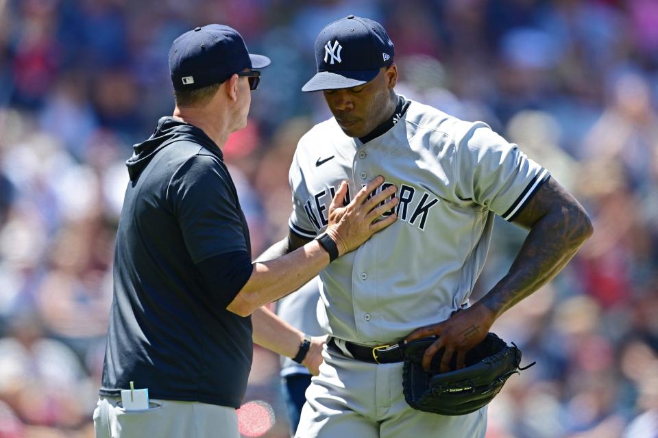 New York Yankees relief pitcher Aroldis Chapman, right, is removed from the game by manager Aaron Boone in the seventh inning in the first baseball game of a doubleheader against the Cleveland Guardians, Saturday, July 2, 2022, in Cleveland. (AP Photo/David Dermer)