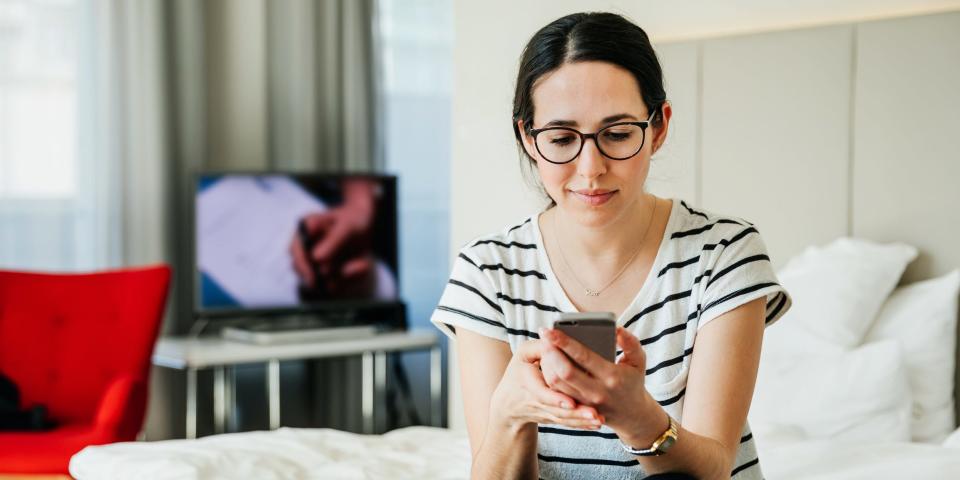woman holding using phone tv movie at home