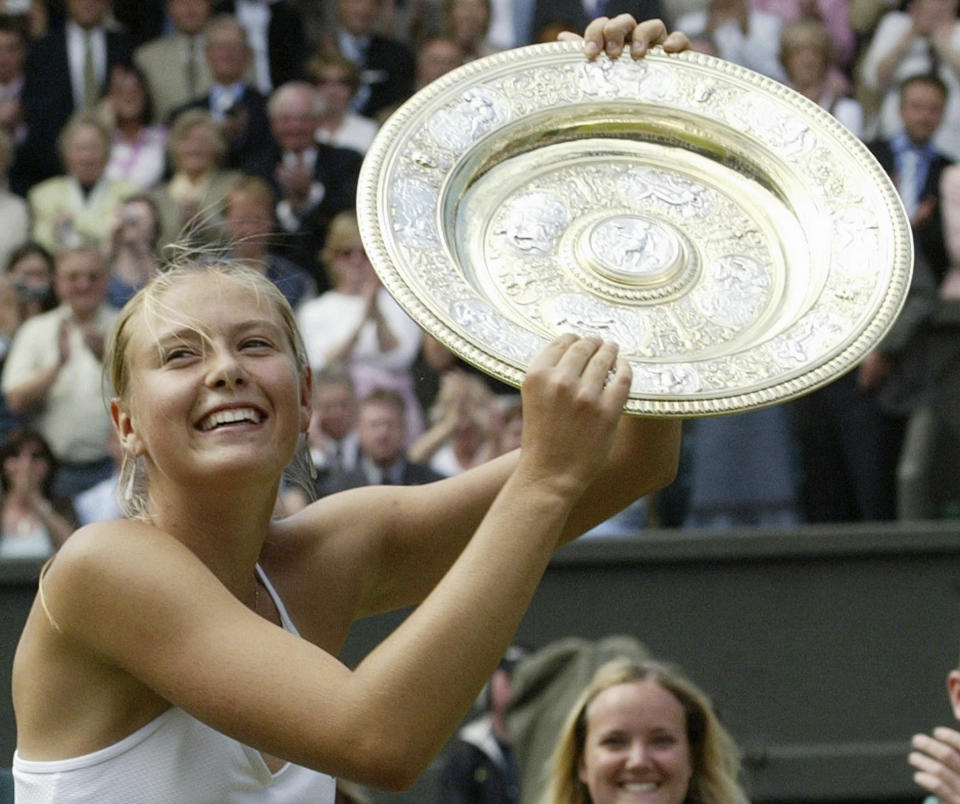 ARCHIVO - En esta foto del 3 de julio de 2004, Maria Sharapova alza el trofeo de campeona del torneo de Wimbledon tras vencer a Serena Williams en la final. (AP Foto/Anja Niedringhaus, archivo)