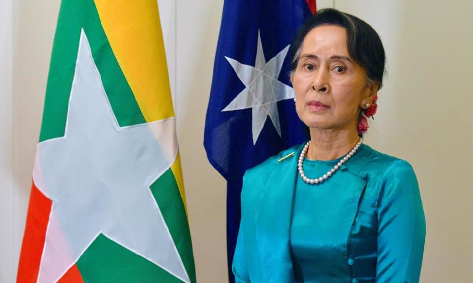 Myanmar’s state counsellor Aung San Suu Kyi stands next to national flags for Australia and Myanmar at Parliament House in Canberra.