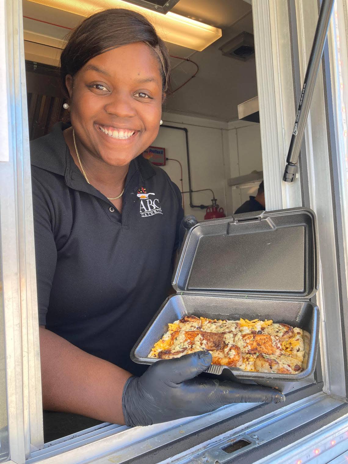Allegra Lowe, owner of ABC Catering LLC, serves up salmon, shrimp and grits from her food truck.