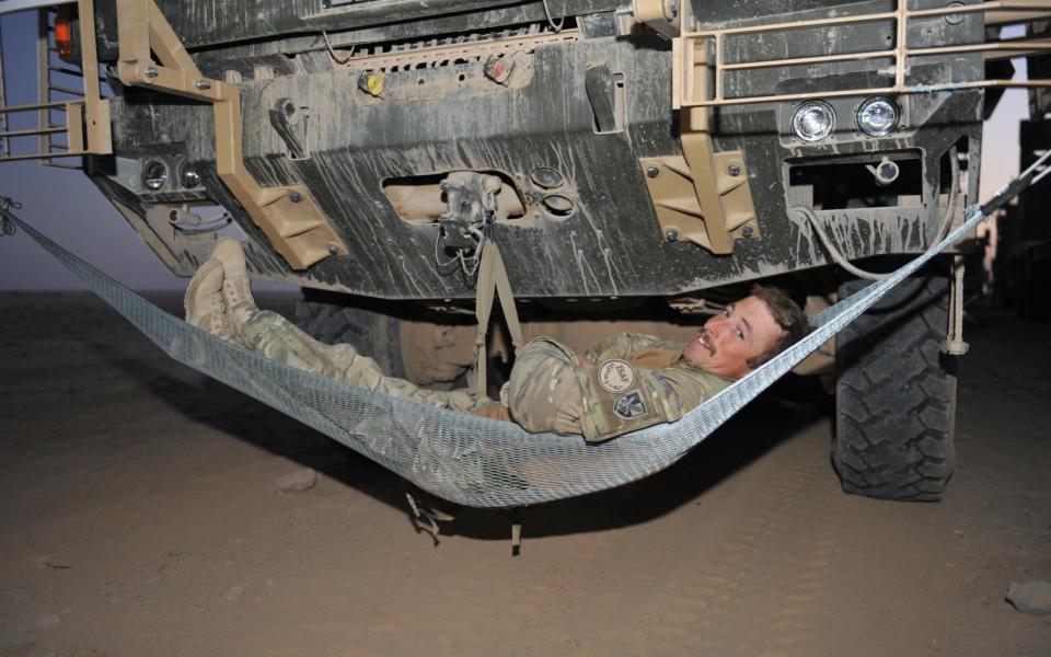 A soldier sets up his bed on an overnight Combat Logistics Patrol, somewhere in the Helmand desert. - Rupert Frere RLC/Crown Copyright