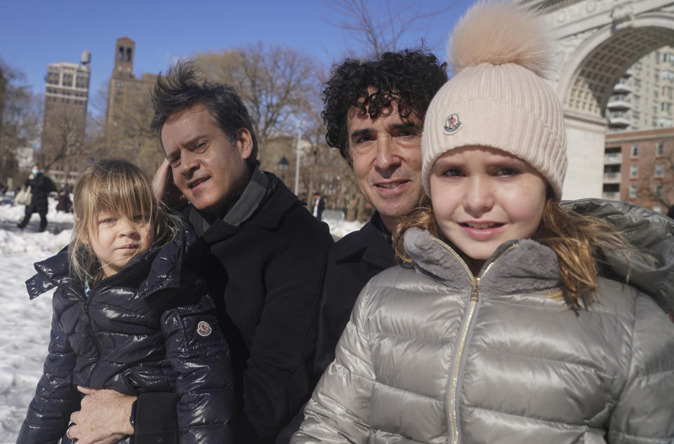 New York State Senator Brad Hoylman, left, with his husband David Sigal, right, pose with their daughters Lucy Hoylman-Sigal, 3, left, and Silvia Hoylman-Sigal, 10, both born through surrogacy, Saturday Feb. 6, 2021, in New York. Sen. Hoylman is the lead sponsor of a New York State law taking effect on Feb. 15 that legalizes commercial surrogacy. (AP Photo/Bebeto Matthews)