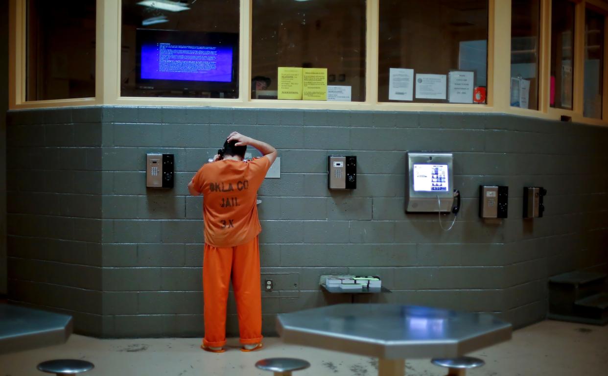 An inmate talks on the phone in the men's mental health unit at the Oklahoma County Jail on Friday, Aug. 7, 2015, in Oklahoma City, Okla.