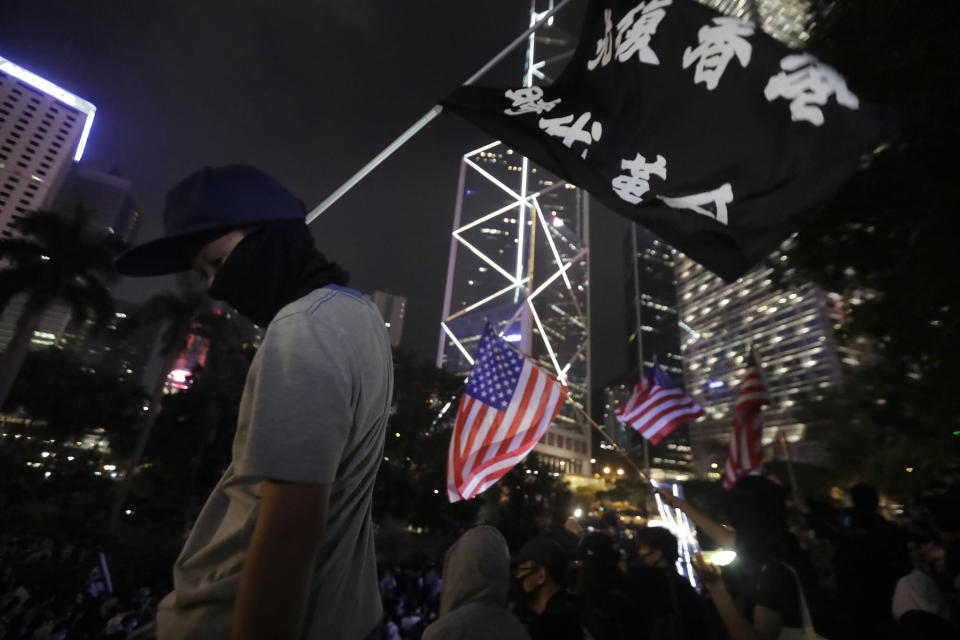 A protester holds a banner with the words "Recover Hong Kong, Era revolution" during a rally in Hong Kong on Saturday, Oct. 26, 2019. Hong Kong authorities have won a temporary court order banning anyone from posting personal details or photos of police officers online, in their latest effort to clamp down on the city's protest movement. (AP Photo/Mark Schiefelbein)