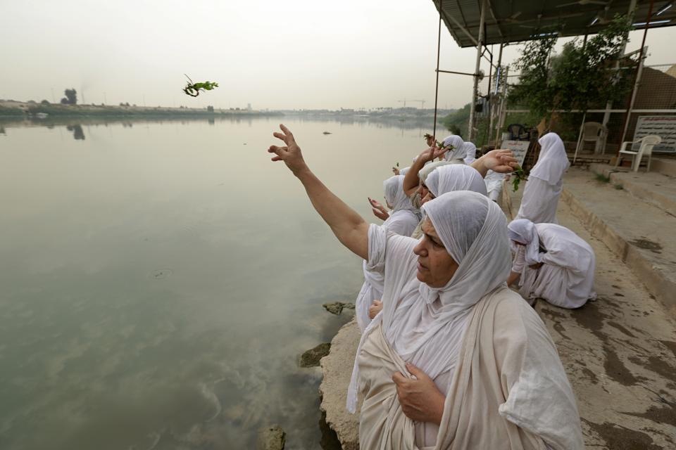 In this Sunday, Oct. 14, 2018 photo, followers of the obscure and ancient Mandaean faith throw parsley from an embankment on the Tigris River as part of their traditional rituals, in Baghdad, Iraq. Until 2003, nearly all the world’s Mandaeans lived in Iraq, but the cycles of conflict since the U.S. invasion have driven minorities out of the country for security reasons and economic opportunity. (AP Photo/Hadi Mizban)