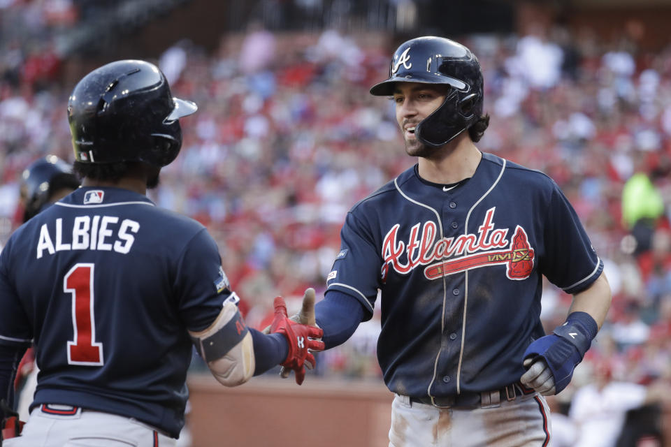 Atlanta Braves' Dansby Swanson, right, celebrates with Ozzie Albies (1) after scoring during the fifth inning in Game 4 of a baseball National League Division Series against the St. Louis Cardinals, Monday, Oct. 7, 2019, in St. Louis. (AP Photo/Charlie Riedel)