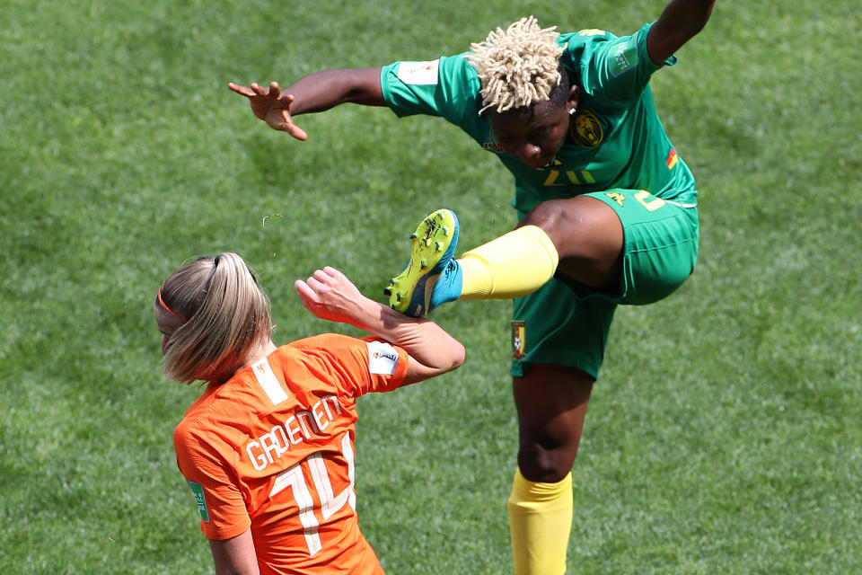 VALENCIENNES, FRANCE - JUNE 15: Genevieve Ngo Mbeleck of Cameroon connects with the arm of Jackie Groenen of the Netherlands as she clears the ball during the 2019 FIFA Women's World Cup France group E match between Netherlands and Cameroon at Stade du Hainaut on June 15, 2019 in Valenciennes, France. (Photo by Charlotte Wilson/Offside/Getty Images)