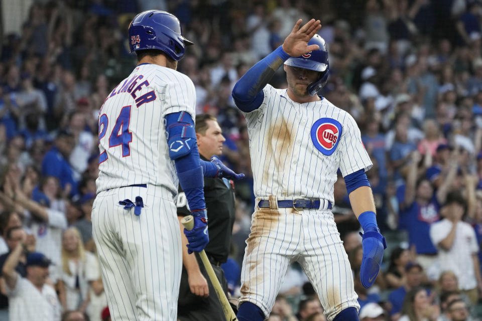 Chicago Cubs' Nico Hoerner, right, celebrates with Cody Bellinger after scoring on a RBI double by Ian Happ during the first inning of a baseball game against the Cincinnati Reds in Chicago, Thursday, Aug. 3, 2023. (AP Photo/Nam Y. Huh)