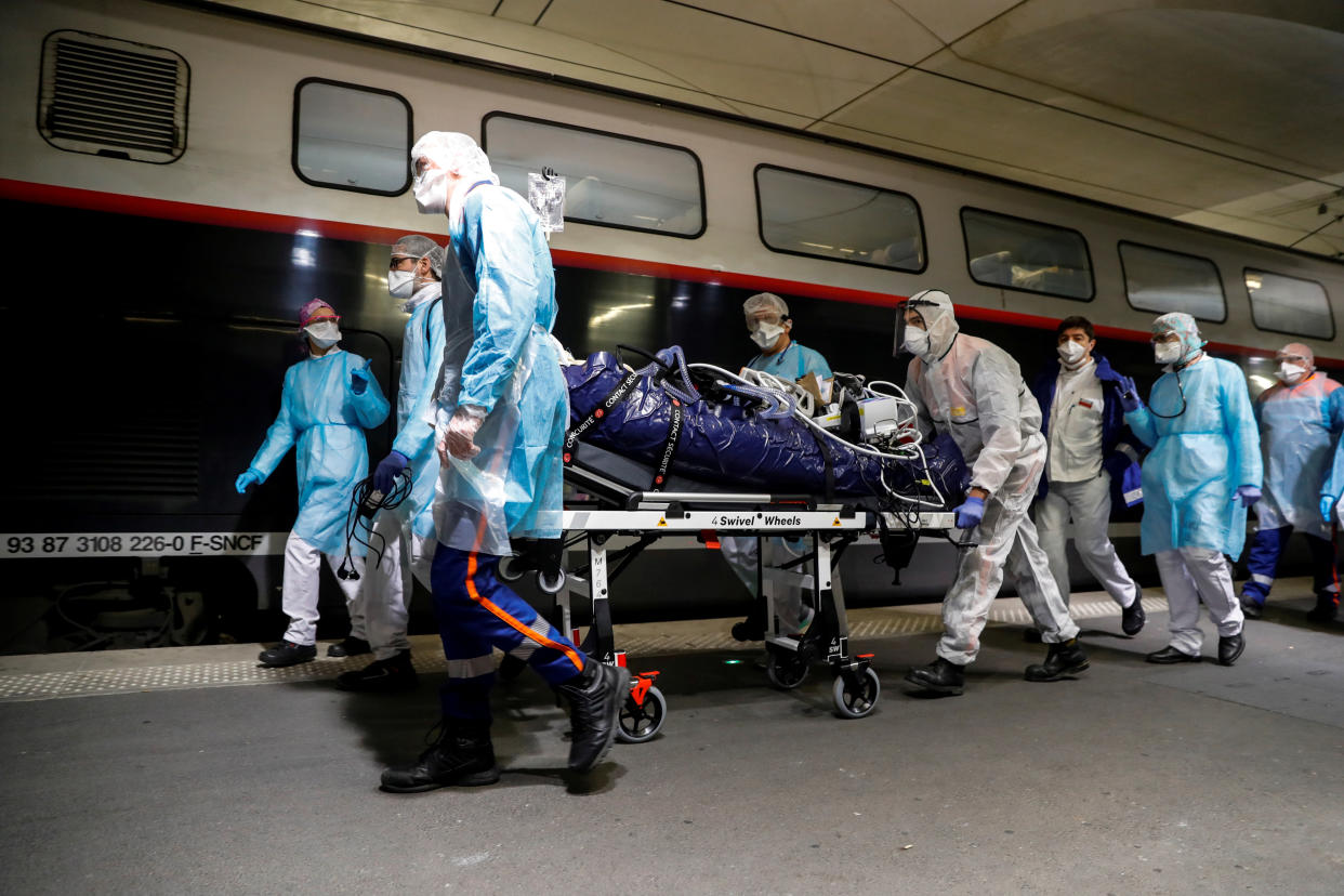 Medics transport a coronavirus patient onto a TGV. (Thomas Samson/Pool via REUTERS)